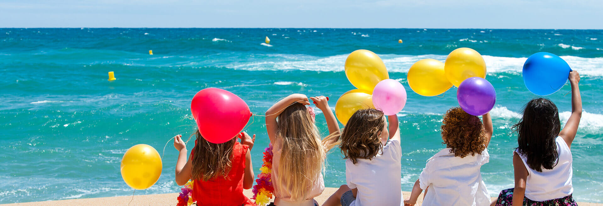 Kids on beach with balloons